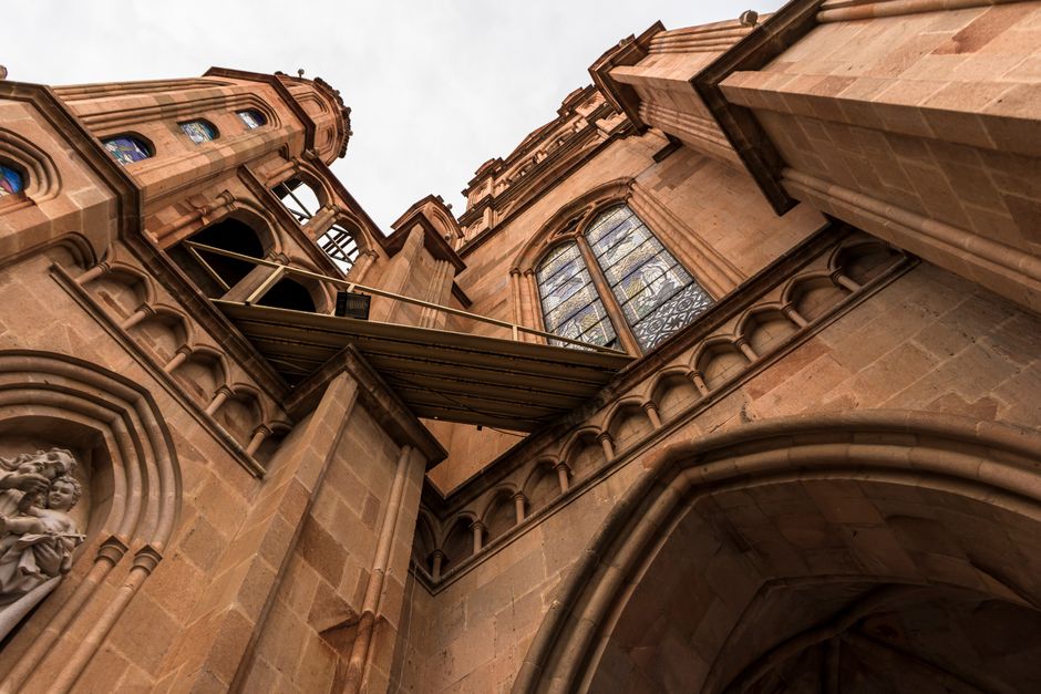 Low angle view of a historic Gothic cathedral showcasing intricate stonework and stained glass windows.