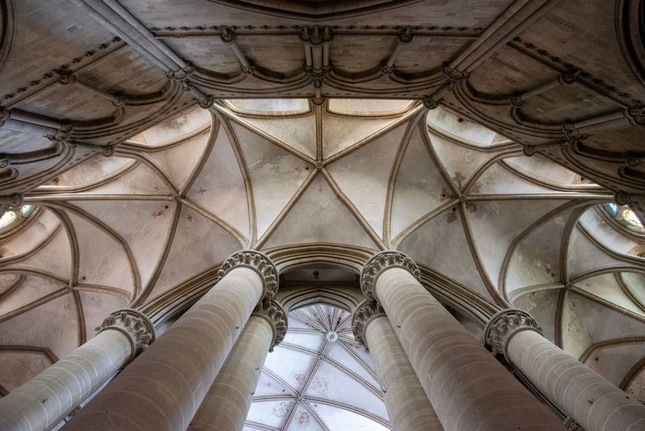 Intricate vaulted ceilings and tall pillars of a historic cathedral interior.